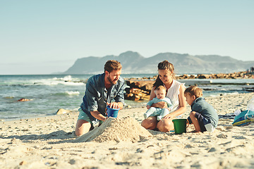 Image showing Sandcastle building, parents and children at beach with bonding, love and support. Baby, mom and dad together with kids playing in the sun with mockup space and smile by the ocean and sea with family