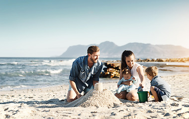 Image showing Sandcastle, happy summer and children at the beach with bonding, love and support. Baby, mom and dad together with kids playing in the sun with mockup space and smile by the ocean and sea with family
