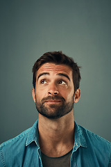 Image showing Man, face and thinking on mockup space for idea, plan or wondering against a grey studio background. Isolated thoughtful male person or model in question, doubt or confused mindset for planning dream