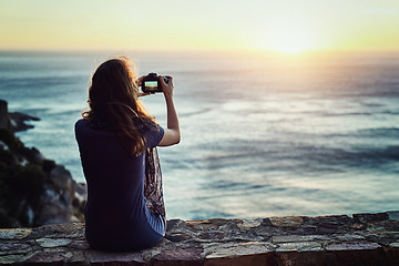 Image showing Woman, camera and sunset photography of beach or enjoying time outside or relax for vacation in summer or in nature and ocean view. Sunrise, female photographer and travel blog for holiday outdoors