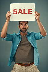 Image showing Man, hands and sale on billboard for advertising, marketing or branding against a grey studio background. Male person or realtor holding board, sign or poster for sales announcement or advertisement