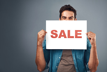 Image showing Man, sale and billboard poster for advertising, marketing or branding against a grey studio background. Male person or realtor holding board or sign for sales announcement, notice or advertisement