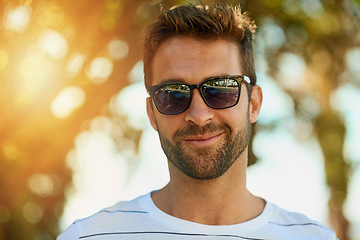 Image showing Confidence, sunglasses and portrait of a man in a park while on a summer vacation, weekend trip or holiday. Smile, happy and face of a young male person from Brazil standing in an outdoor garden.