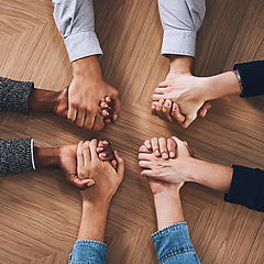 Image showing Above, partnership or business people holding hands for support, teamwork or strategy in office. Motivation, zoom or employees in group collaboration with diversity or mission for goals together