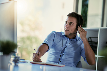 Image showing Callcenter agent, smile and notes, man consulting with advice, sales information and help desk. Phone call, conversation and customer support consultant writing in notebook while speaking in office.