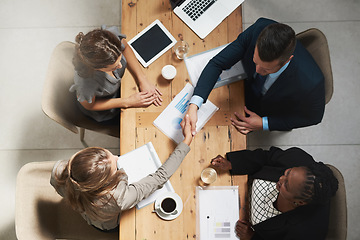 Image showing Business people, handshake and meeting with documents above for hiring, partnership or collaboration at the office. Top view of businessman shaking hands for recruiting, teamwork or marketing project