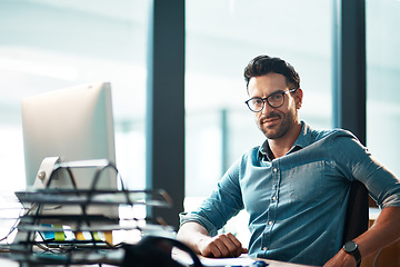 Image showing Business man, portrait and working at computer, office desk or confidence for web development in IT company. Young software developer at desktop in professional startup with pride, glasses and agency