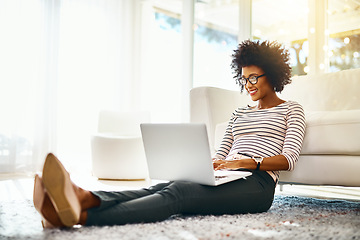 Image showing Young woman, laptop and living room floor relax doing online shopping sitting on ground. Home, happiness and computer typing of African female person on a ecommerce app reading PC deal with smile