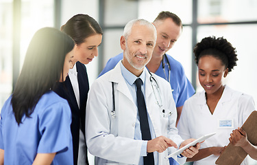 Image showing Senior doctor, team or group with tablet, smile and portrait for leadership, discussion or planning together in hospital. Medic man, mentor and medical student with teamwork, women and healthcare job