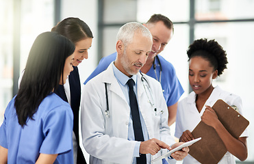 Image showing Senior doctor, tablet and coaching intern in healthcare for research, teamwork or meeting at the hospital. Elderly medical professional training staff on technology in team diversity or collaboration