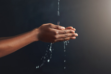 Image showing Washing hands, water and person cleaning palm for hygiene isolated in a dark or black studio background. Stream, splash and hand clean for wellness or hydration with germ protection or bacteria