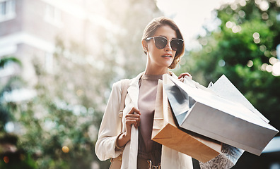 Image showing Fashion, shopping bag or rich woman in city or street for boutique retail sale, or clothes discount deals. Sunglasses, financial freedom or trendy girl customer walking on road with luxury products