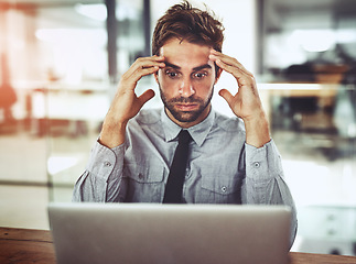 Image showing Businessman, laptop and headache in stress, anxiety or burnout in shock from debt at office desk. Frustrated man person or employee with bad head pain or overworked in financial crisis at workplace