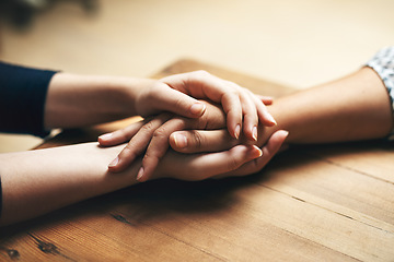 Image showing Holding hands, cancer and support of friends, care and empathy together on table in home mockup. Kindness, love and women hold hand for hope, trust or prayer, comfort or compassion, help or unity.