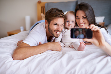 Image showing Mother, father and smile for selfie with baby on bed in home for love, care or social media together. Happy family, parents and cute kid taking photograph for memory, happiness and relax in bedroom