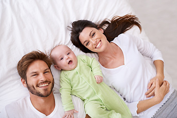 Image showing Top view, portrait and happy parents with baby on bed for love, care and quality time together at home. Smile of mother, father and family with cute newborn kid relaxing in bedroom, fun and happiness