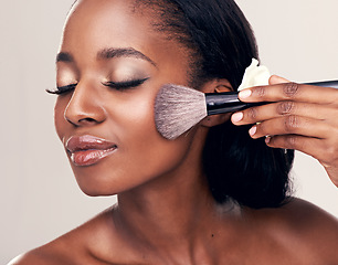 Image showing Beauty, makeup and black woman with brush on face in studio and cosmetic application tool. Skincare, blush and cosmetics, facial skin care model with happiness and luxury shine on white background.