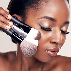 Image showing Beauty, makeup and brushes on face, black woman with cosmetic tools in studio with application tool. Skincare, blush and cosmetics, closeup of facial care model with luxury powder on white background