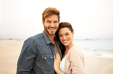 Image showing Couple, portrait and embrace at beach for travel, romance and freedom together outdoors. Face, smile and happy woman hugging man on trip, vacation or holiday, bond or having fun standing in Bali