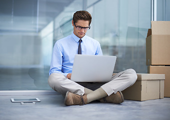 Image showing Moving boxes, office laptop and man reading business report, online information or search web, internet or website info. Relocation, cardboard box and male worker, employee or person sitting on floor