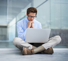 Image showing Laptop, office and man focus, thinking and stress over business finance report, feedback analytics or financial loss. Reading, statistics analysis and person problem solving mistake error on floor