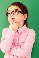 Image showing Green screen, ideas and girl with focus, future and decision against a studio background. Female child, geek and nerd with glasses, thoughts and thinking with young person, choice and opportunity