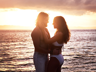 Image showing Happy couple, hug and sunset at the beach for love, quality time or bonding together in the water. Man and woman hugging in loving romance, sunrise or sunshine in the ocean for romantic holiday