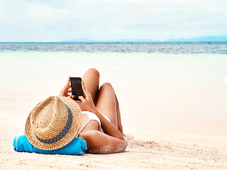 Image showing Travel, phone and woman relaxing on the beach scrolling on social media or mobile app on holiday. Rest, tropical and female person laying on sand by ocean networking on cellphone on summer vacation.