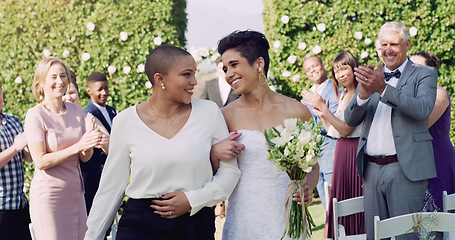 Image showing Wedding, happiness and interracial lesbian couple walking down aisle with smile, love and applause. Lgbt marriage, celebration and happy women at ceremony or reception with lgbtq pride and commitment