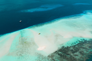 Image showing Top view, blue ocean and island shore of water for travel, journey or adventure at sea. Big beach view of calm, peaceful or serene tropical waters above and natural scenic environment for vacation