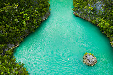 Image showing Travel, aerial and man swimming on island for adventure, holiday and summer vacation in Mauritius. Nature, seascape and drone view of person in tropical water, destination and traveling on islands