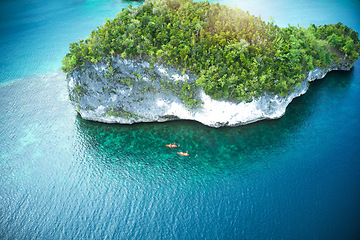 Image showing Drone, island and water adventure with people in kayak for travel, freedom and fun in nature. Top view, paradise and friends canoeing in Indonesia, relax and zen, peace or beautiful outdoor scenery