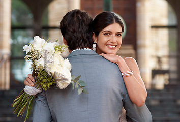 Image showing Flowers, wedding and love with a married couple hugging outdoor together after a ceremony of tradition. Hug, marriage or commitment with a man and woman outside looking happy as husband and wife