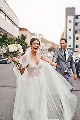 Image showing Wedding, run and a happy couple in a city outdoor together after a ceremony of tradition or love. Flowers, marriage or smile with a man and woman holding hands while running as husband and wife