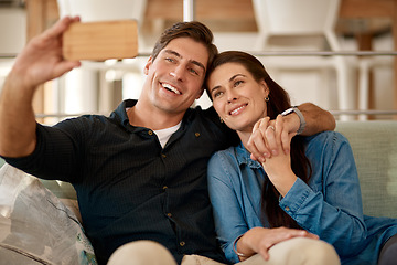 Image showing Couple, couch and selfie in home for smile, holding hands or pride for love, care or internet app. Man, woman and happy for photography, profile picture or social media for bond, relax or lounge sofa