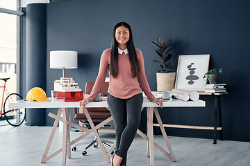 Image showing Portrait, architect and asian woman in office with engineering plan, blueprint and construction helmet. Face, female worker in professional architecture company workplace with confidence and smile