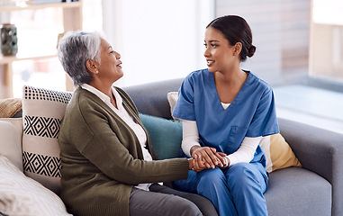 Image showing Support, caregiver holding hands with a senior woman and on sofa at nursing home for care. Consulting or healthcare conversation, communication with nurse and elderly female patient talking on couch