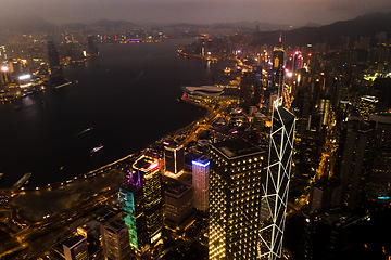 Image showing Aerial, skyscrapers and night city of office buildings with lake, lights and riverside in the outdoors. Drone view of CBD, architecture or cityscape and late infrastructure lighting of a urban town