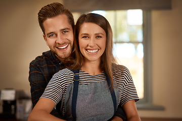 Image showing Love, portrait of couple smiling and hugging from the back in a kitchen of their home. Married or relationship, caring or happy and cheerful or excited man cooking with woman in apron in their house