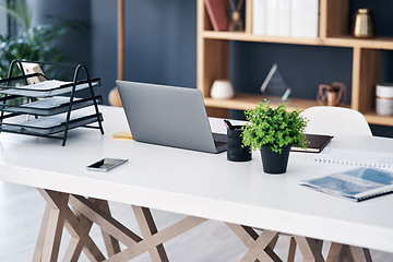 Image showing Office desk, business workspace and laptop with professional setup at digital marketing startup. Workstation, paperwork and notebook with work supplies, technology and pc on table in empty workplace