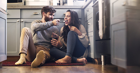 Image showing Ice cream, kitchen and couple on floor in home for bonding, relaxing and quality time together. Love, relationship and happy man and woman with sweet treats, dessert and luxury snack for romance