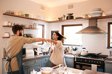 Image showing Excited young couple, dance and kitchen in home with love, comic moment and cooking together with romance. Man, woman and smile with dancing, moving and happiness for food, nutrition or diet in house