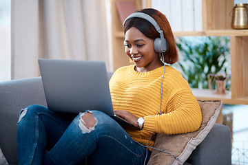 Image showing Black woman with laptop, headphones and relax on sofa, search online for movie and streaming subscription at home. Happy African female person in apartment, connectivity and watching on pc with web