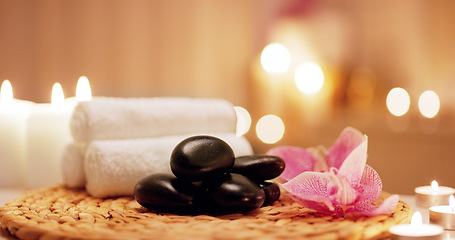 Image showing Candles, towels and hot stones at a spa for a massage, healing or luxury treatment therapy. Health, aromatherapy and wellness body care products for a calm, zen or peace atmosphere at a natural salon