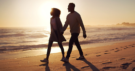 Image showing Couple holding hands, walking on beach at sunset and ocean with silhouette, vacation and travel with mockup space. Love, romance and trust with people in commitment, tropical holiday and sea view