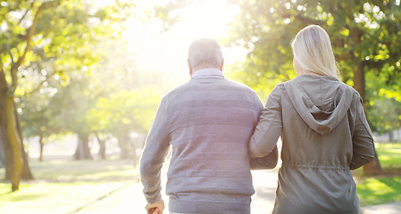 Image showing Senior man, woman and walking outdoor in a park for support, love and care. Back of elderly father with a cane and daughter on walk for a healthy retirement, life insurance and family time in nature