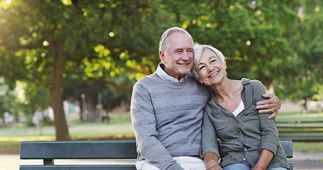 Image showing Senior couple, bench and happy outdoor in a park with love, care and support in marriage. A elderly man and woman hug in nature with a smile for quality time, healthy retirement and freedom to relax