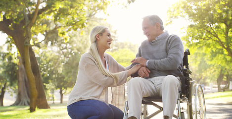 Image showing Happy, talking and man in wheelchair with a woman in nature for care and support. Holding hands, smile and an elderly person with a disability and a daughter with love and conversation in a park