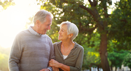 Image showing Senior couple, walking and happy outdoor at a park with love, care and support for health and wellness. A elderly man and woman in nature for a walk, quality time and healthy marriage or retirement