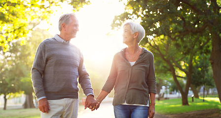 Image showing Happy, walking and a senior couple outdoor at a park with love, care and support. A elderly man and woman holding hands in nature for commitment, quality time and healthy marriage or retirement